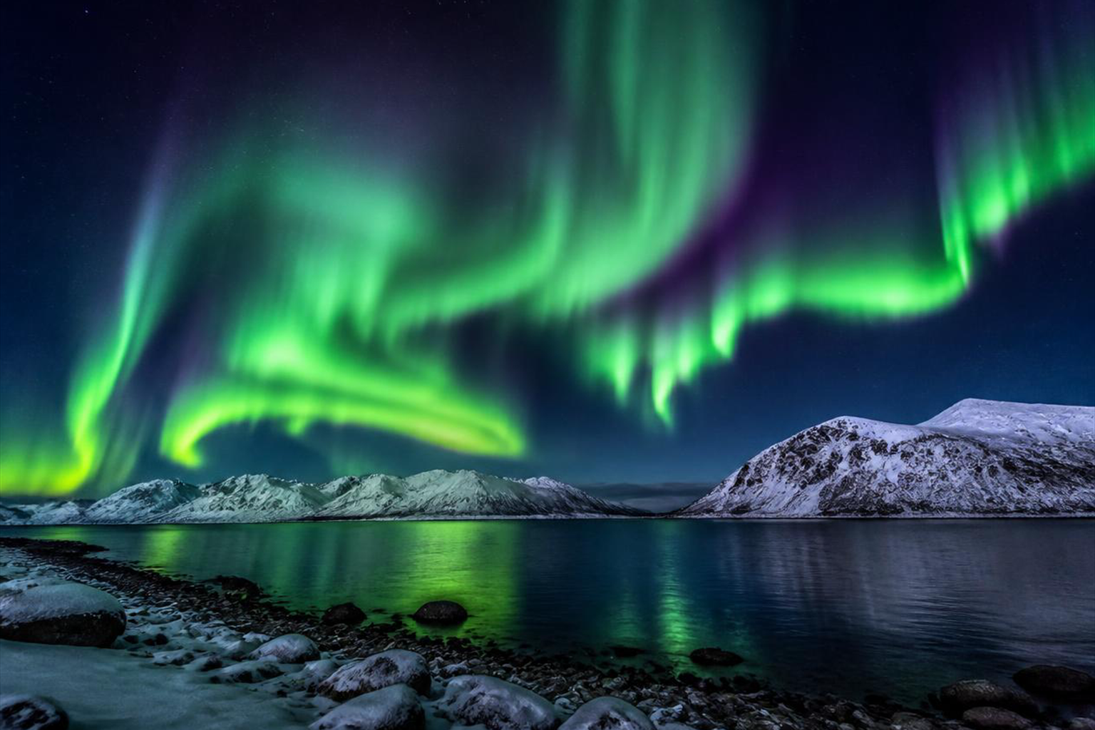 Green aurora over a quiet mountain lake